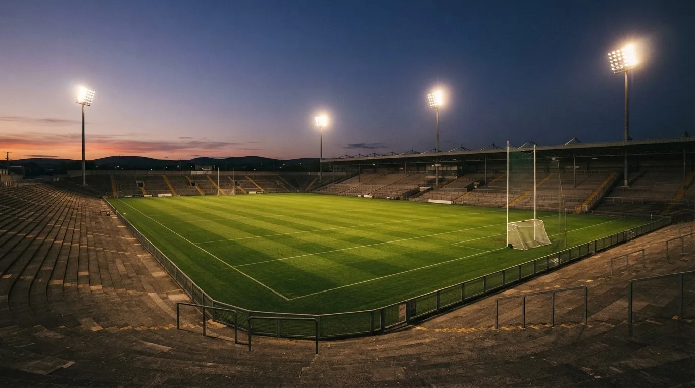 An empty football stadium with floodlight masts at dusk