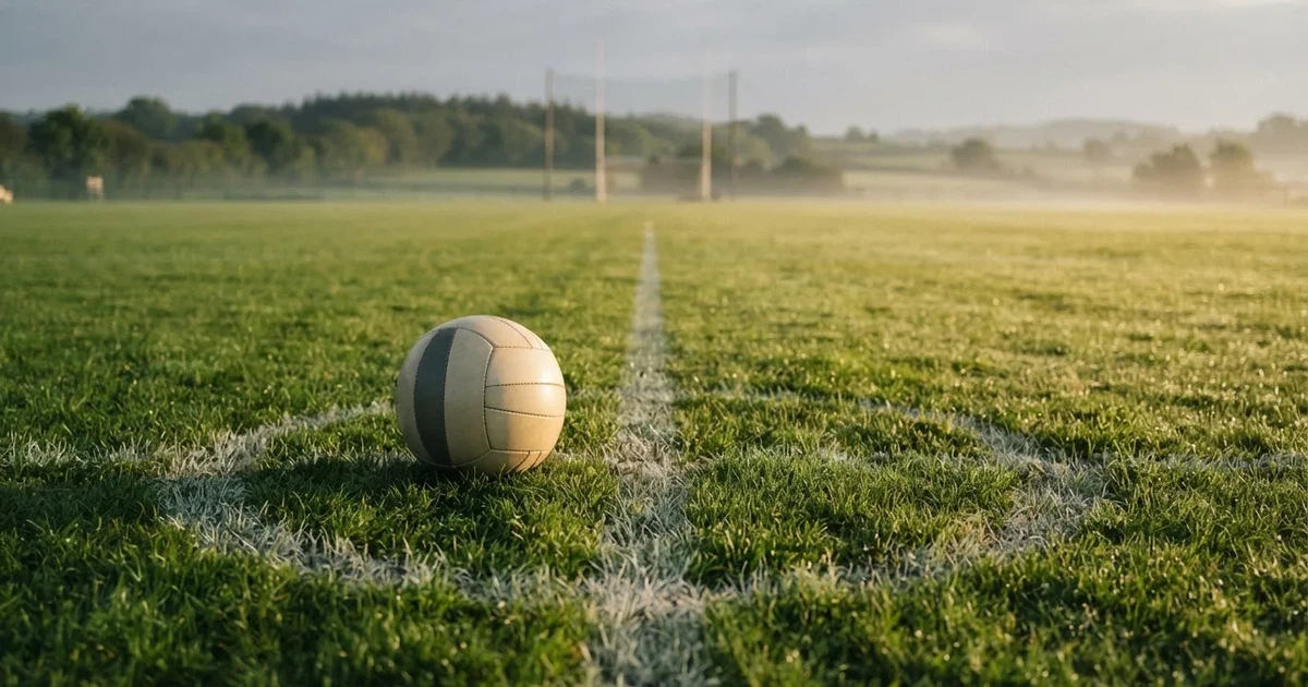 A ball on the centre spot of a grass pitch in morning light